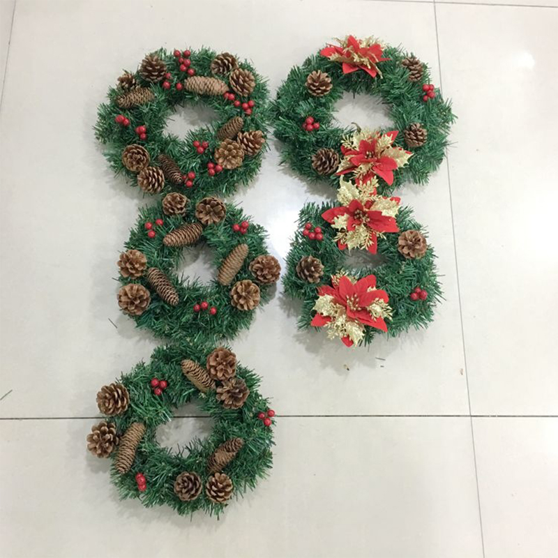 Christmas wreath with poinsettia, pinecones and red berries