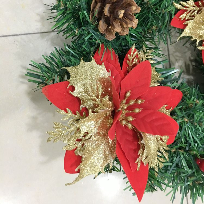 Christmas wreath with poinsettia, pinecones and red berries